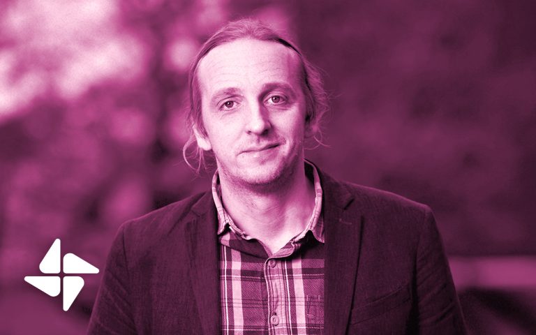 Porträttbild av Martin Schibbye. Hon ser in i kameran, klädd i kostym och en skjorta.