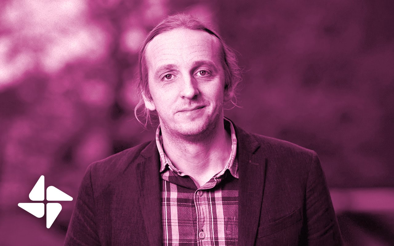 Porträttbild av Martin Schibbye. Hon ser in i kameran, klädd i kostym och en skjorta.